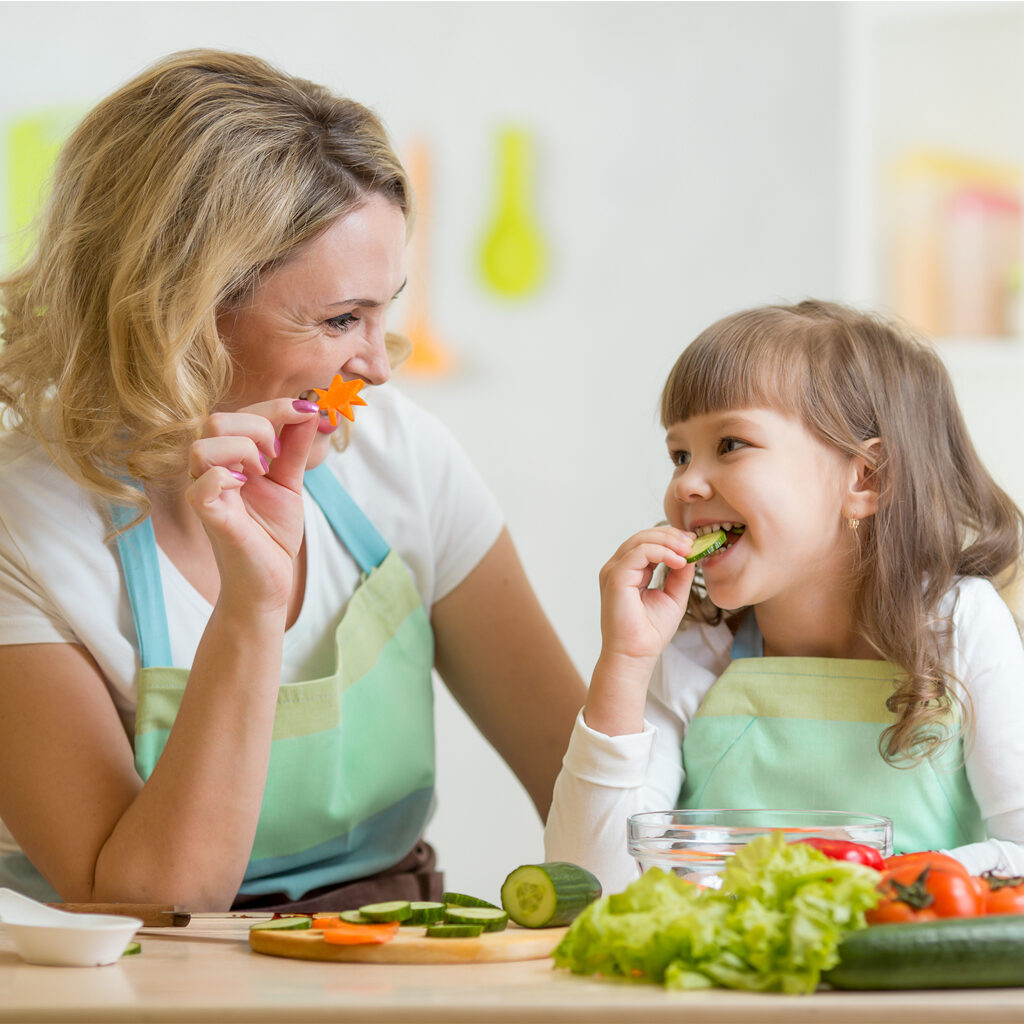 kid girl and mother eating healthy food vegetables