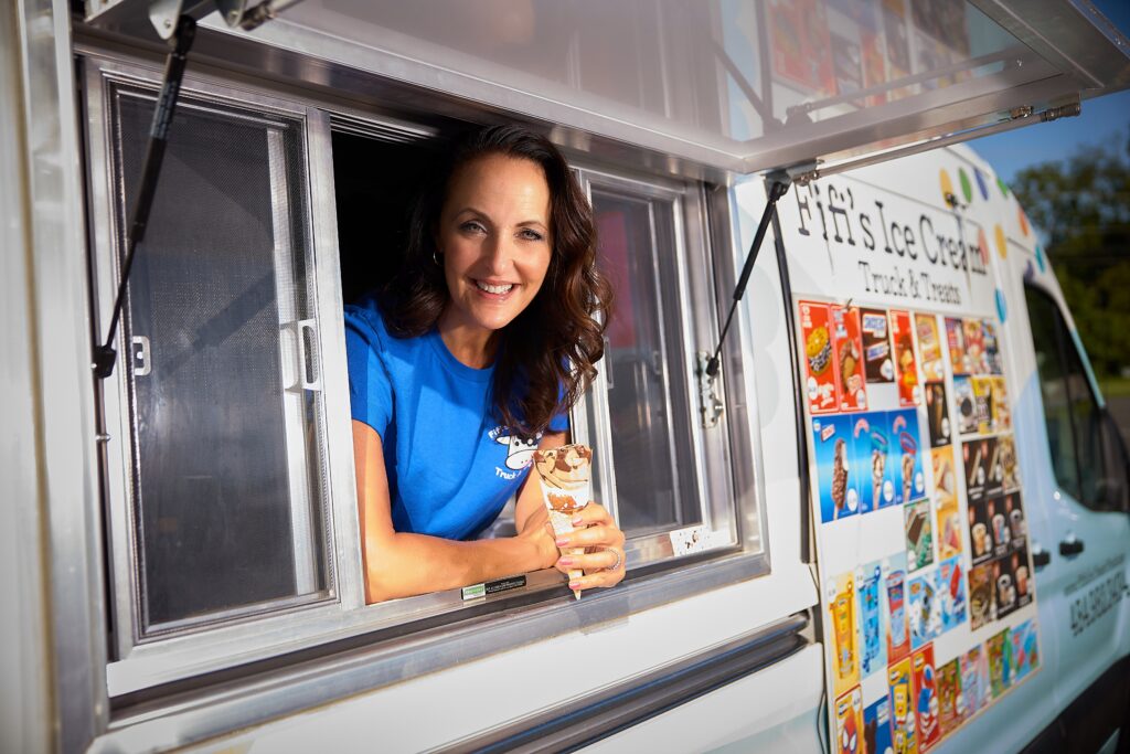 Thea Tantaros holds a chocolate ice cream cone out of the window of her Fifi's Ice Cream truck.