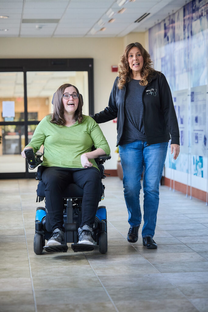 Emily Brong walks with Tamie Sturgis inside Good Shepherd Rehabilitation's Hyland Center for Healthy & Technology in Allentown, Pa.