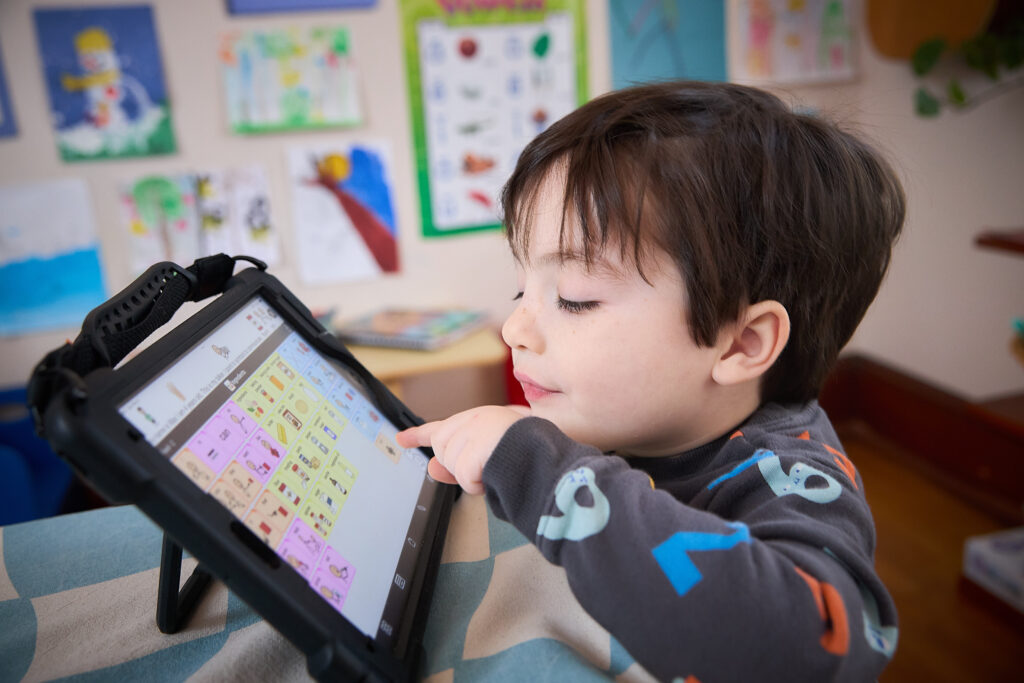 Maxwell Kerr shows his augmentative and alternative communication (AAC) tablet, which helps him communicate.