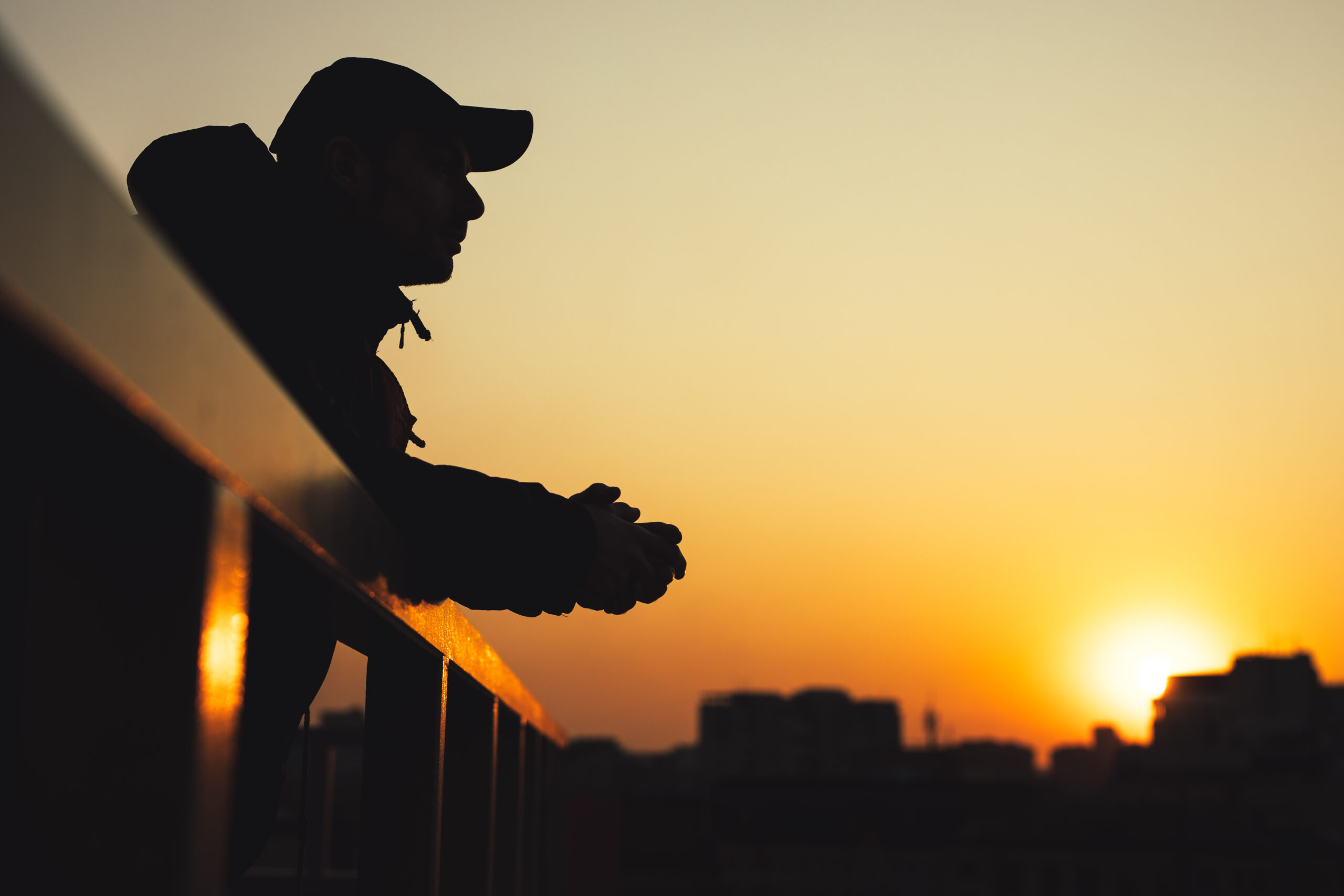 A silhouette of a person looking out at the horizon